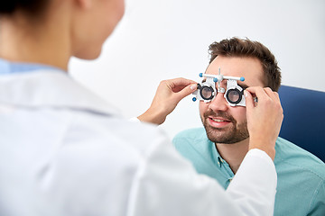 Image showing optician with trial frame and patient at clinic