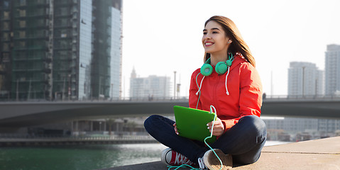 Image showing happy young woman with tablet pc and headphones