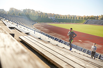 Image showing happy couple running upstairs on stadium