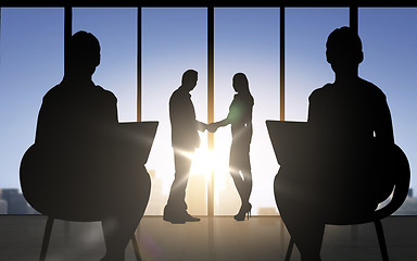 Image showing business partners silhouettes shaking hands