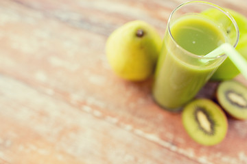 Image showing close up of fresh green juice and fruits on table