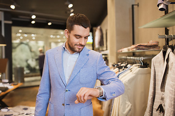 Image showing happy man in jacket with watch at clothing store