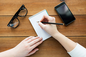 Image showing close up of woman or student writing to notepad