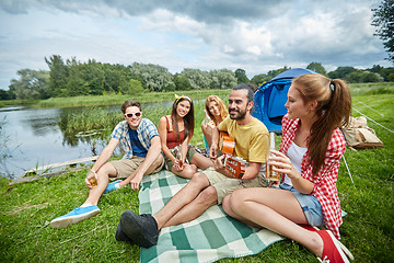 Image showing happy friends with drinks and guitar at camping