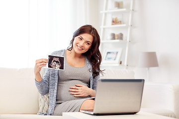 Image showing happy pregnant woman with ultrasound image at home