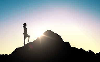 Image showing silhouette of businesswoman raising up to mountain