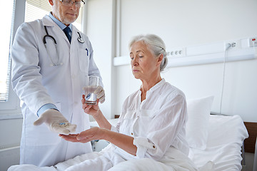 Image showing doctor giving medicine to senior woman at hospital