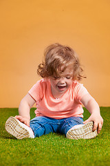 Image showing One cute baby girl on orange background