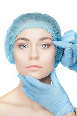 Image showing Plastic surgery concept. Doctor hands in gloves touching woman face