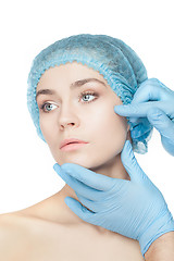 Image showing Plastic surgery concept. Doctor hands in gloves touching woman face