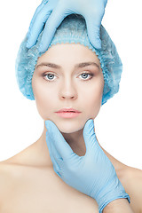 Image showing Plastic surgery concept. Doctor hands in gloves touching woman face