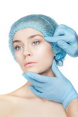 Image showing Plastic surgery concept. Doctor hands in gloves touching woman face