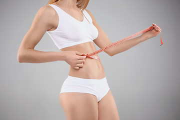 Image showing Woman holding meter measuring perfect shape of her beautiful body