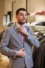 Image showing young man trying suit on in clothing store