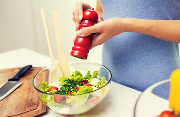 Image showing close up of woman cooking vegetable salad at home