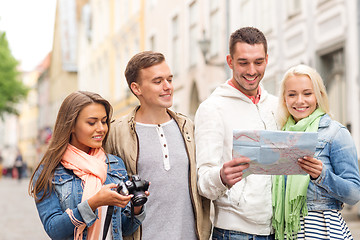 Image showing group of smiling friends with map and photocamera