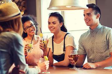 Image showing happy friends drinking beer and cocktails at bar