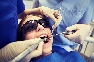 Image showing female dentists treating patient girl teeth