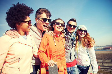 Image showing happy teenage friends with longboards on street