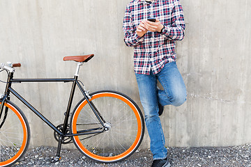 Image showing close up of hipster man with smartphone and bike