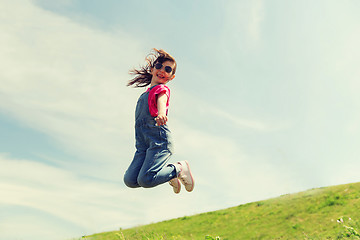 Image showing happy little girl jumping high outdoors