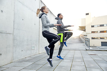 Image showing happy man and woman jumping outdoors