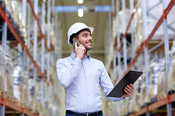 Image showing man with clipboard and smartphone at warehouse