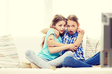 Image showing scared little girls watching horror on tv at home