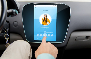Image showing close up of male hand using music player in car