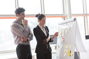 Image showing young couple working on flip board at office