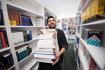 Image showing Student holding lot of books in school library