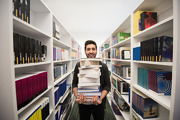 Image showing Student holding lot of books in school library