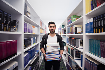 Image showing Student holding lot of books in school library