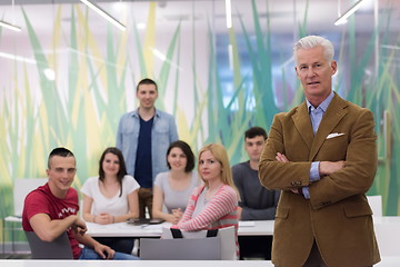 Image showing portrait of  teacher with students group in background