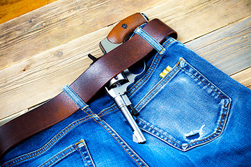 Image showing old revolver tucked behind a leather belt