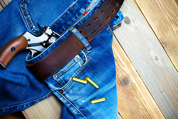 Image showing fashion old blue jeans and vintage revolver