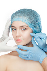 Image showing Plastic surgery concept. Doctor hands in gloves touching woman face