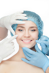 Image showing Plastic surgery concept. Doctor hands in gloves touching woman face