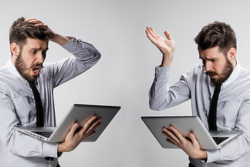 Image showing The young confused and frustrated man with his laptop computer