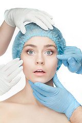 Image showing Plastic surgery concept. Doctor hands in gloves touching woman face