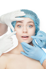 Image showing Plastic surgery concept. Doctor hands in gloves touching woman face