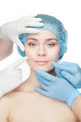 Image showing Plastic surgery concept. Doctor hands in gloves touching woman face