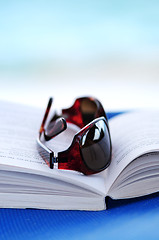 Image showing Sunglasses and book on beach chair