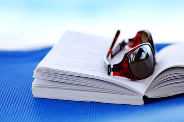 Image showing Sunglasses and book on beach chair