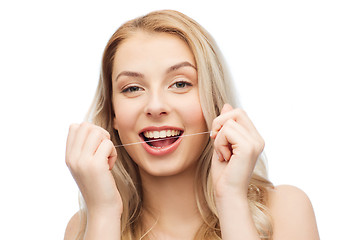 Image showing happy young woman with dental floss cleaning teeth