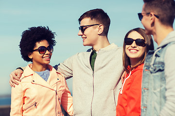 Image showing happy teenage friends in shades talking on street