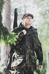 Image showing young soldier or hunter with gun in forest