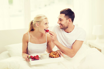 Image showing happy couple having breakfast in bed at home