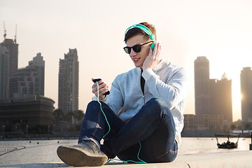 Image showing happy young man in headphones with smartphone