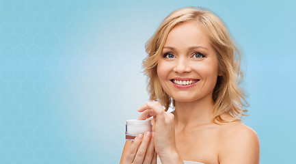 Image showing happy woman with cream jar